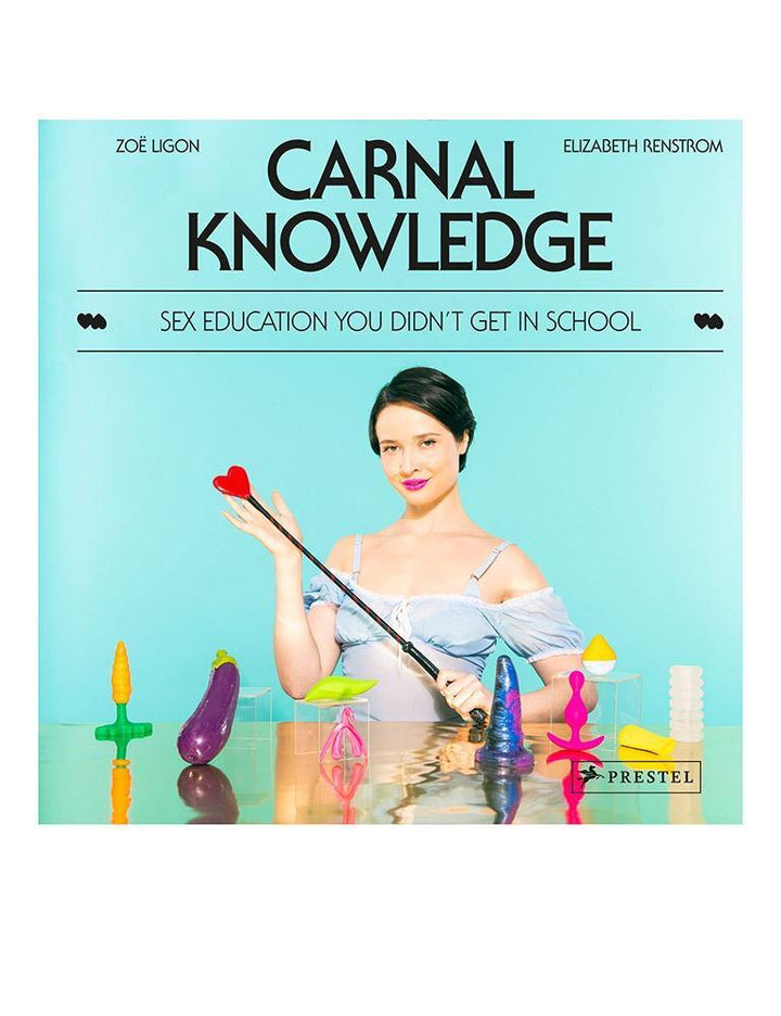 A photo of the cover of the book Carnal Knowledge by Zoë Ligon and Elizabeth Renstrom is displayed against a blank background. The cover is blue and depicts a woman sitting at a table with sex toys.