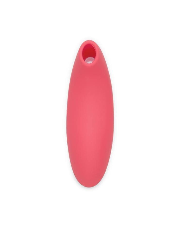  The We-Vibe Melt Pleasure Air Clitoral Vibrator in Coral is shown next to a cell phone against a blank background. The cell phone screen shows the app that can be used to control the toy.