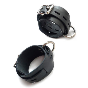 The Locking/Buckling Leather Bondage Restraints in black are shown cuffed against a blank background. The cuffs have one thick piece of leather, and one thinner piece with notches in it that wraps around the thicker piece and is buckled into place.