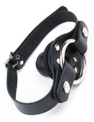 The Locking Ball Gag with a Dildo Ring is shown against a blank background. The gag is a small rubber ball attached to a black plate, which is attached to an adjustable leather strap. On the outer side of the plate is a metal O-ring.