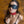 Load image into Gallery viewer, A photo of a brunette woman wearing a black blindfold and bra is taken from above. Her arms are behind her back, and she wears the Red Deluxe Buckling Collar.
