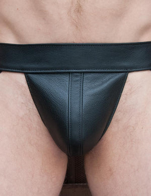 A close-up of a man's groin is shown. He wears the black Leather Jockstrap from The Stockroom.