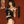 Load image into Gallery viewer, A woman with dark hair stands against a red wall. She wears a black latex bustier, panties, a garter belt, and stockings. Over her shoulder, she is holding the black 18&quot; Basic Suede Flogger.
