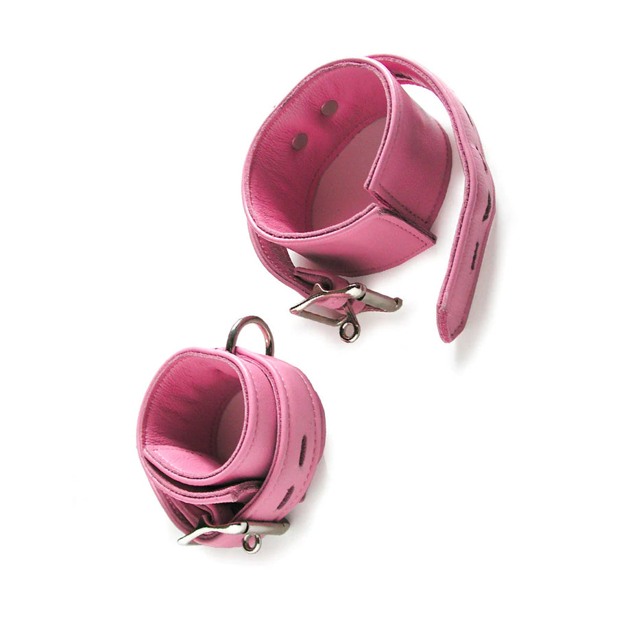 A pair of pink Premium Garment Leather Ankle Cuffs are displayed against a blank background, with one of them uncuffed. They are made of light pink leather with silver hardware. Each cuff has one D-ring, and they fasten with lockable buckles.