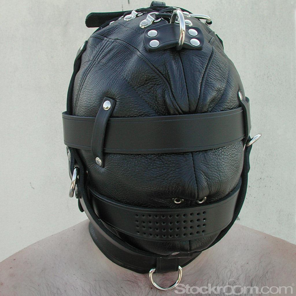 A person's head in the Heavy Duty Leather Hood is shown. It is made of black leather with silver hardware and covers the person's head and neck. Straps are wrapped around the eyes, mouth, neck, and chin. There are small holes for the nose and mouth.