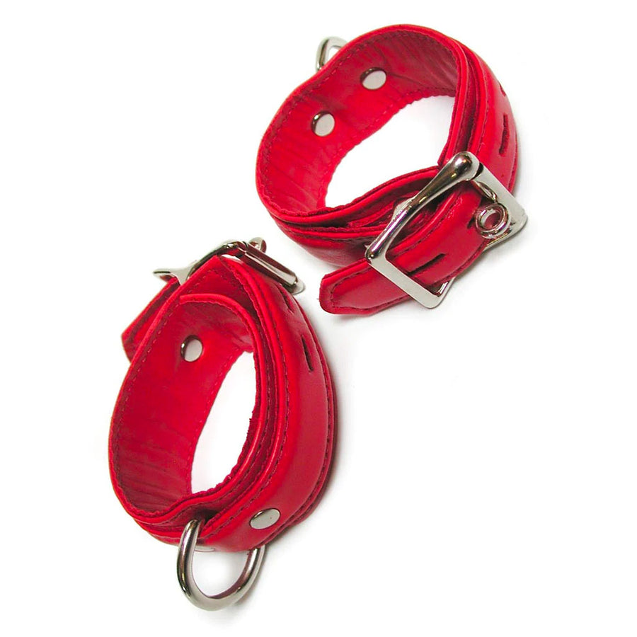 A pair of Premium Garment Leather Wrist Cuffs in red are shown against a blank background. The cuffs are made of red leather with silver hardware. They each have a D-ring and a lockable metal buckle.