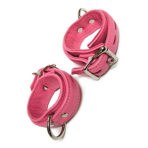 A pair of Premium Garment Leather Wrist Cuffs in pink are shown against a blank background. The cuffs are made of pink leather with silver hardware. They each have a D-ring and a lockable metal buckle.