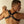 Load image into Gallery viewer, A shirtless man is shown from the mid-back up, facing a white wall. He wears The Contender black Leather BDSM Chest Harness, which is shaped like an X with an O-ring in the center. There are three metal rivets on each strip of leather.
