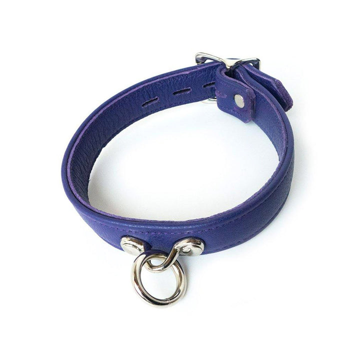 The purple Premium Garment Leather Collar is displayed against a blank background. It is made of a thin band of purple leather with silver hardware. The collar has an O-ring in the center.