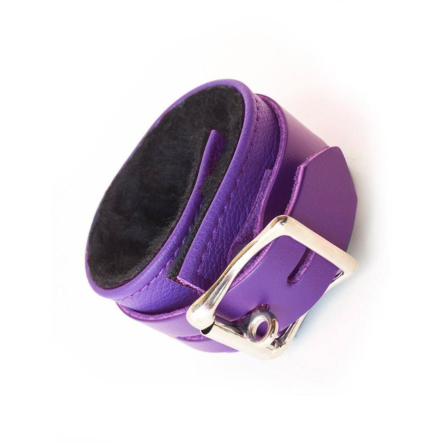 A single Purple Fleece Lined Garment Leather Wrist Cuff is displayed against the background. It is rotated so that the cuff’s lockable buckle is visible.