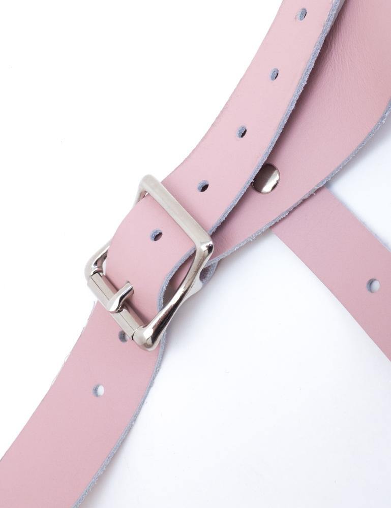 A close-up of a hip strap from the pink Vanity Strapon Dildo Harness is displayed against a blank background.
