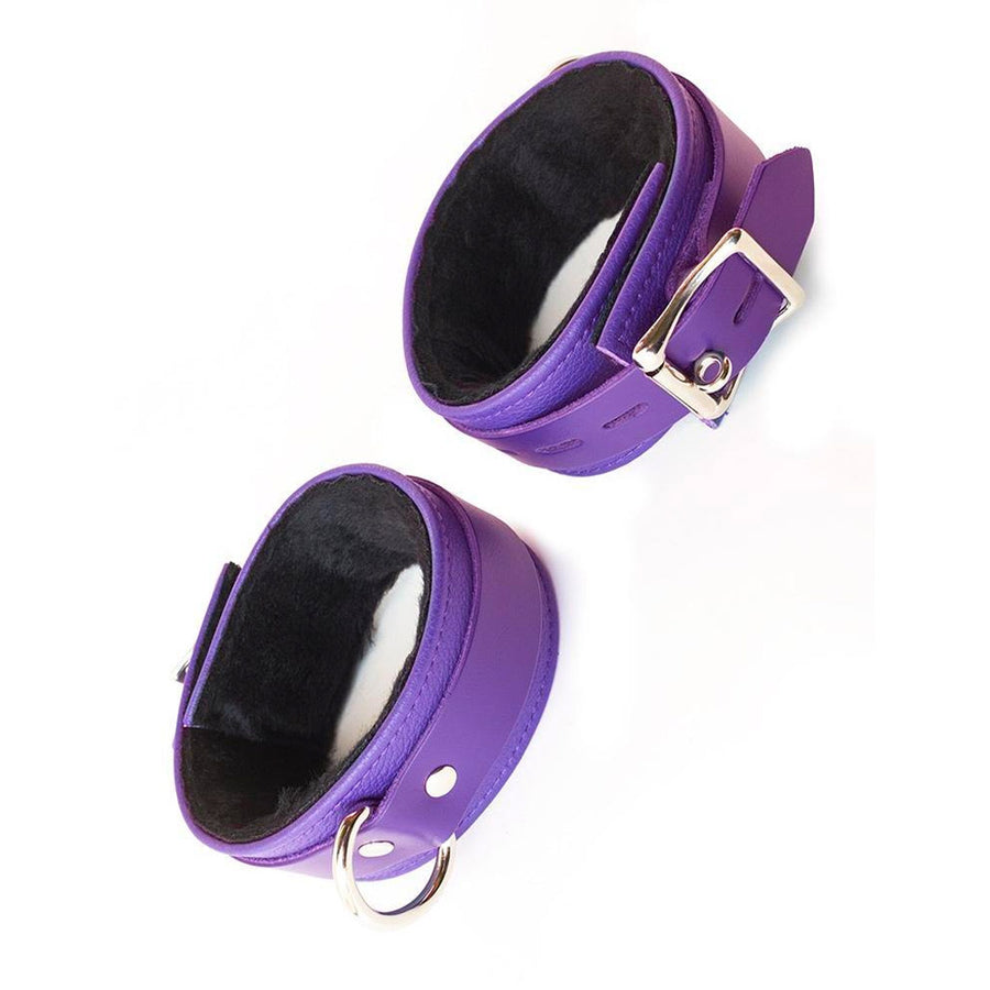 The Purple Fleece Lined Garment Leather Ankle Cuffs are displayed against a blank background. They are made of purple leather with silver hardware, and the interior of the cuffs is lined with black fleece.