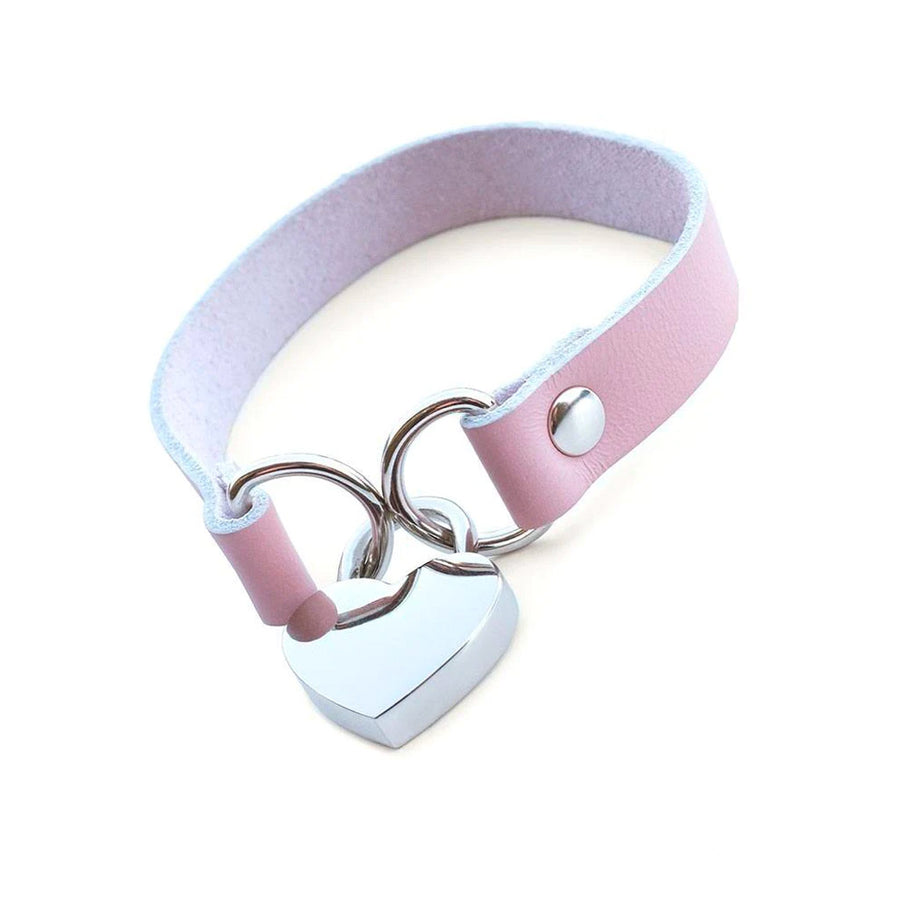 The Stupid Cute Heart Lock Choker is shown against a blank background. It is light pink with silver hardware.