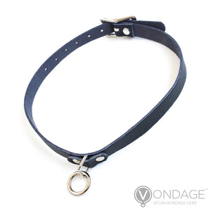 The Vondage Choker With O-Ring is shown against a blank background. It is made of a thin piece of black vegan leather and metal hardware.