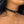 Load image into Gallery viewer, A close-up of a woman&#39;s neck is shown. She wears the Vondage Choker With O-Ring. The collar is made of a thin strip of black vegan leather with a thin metal D-ring in the center. A small metal O-ring dangles from the D-ring. 
