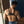 Load image into Gallery viewer, A shirtless muscular man in blue jeans is shown from behind. He wears the black Vondage Mercenary Suspenders, which have an hourglass-shaped piece of vegan leather in the center from which the straps extend over his shoulders and around his chest.
