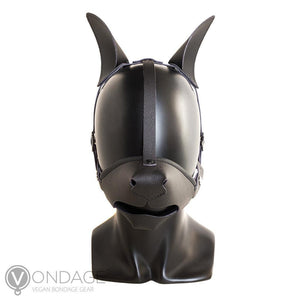 The Vondage Pet Play K9 Muzzle with Removable Ball Gag is shown on a mannequin head. The muzzle is shaped like a dog snout and has a dog nose on it. A black strip of leather runs from the nose to the top of the head, where the dog ears are.