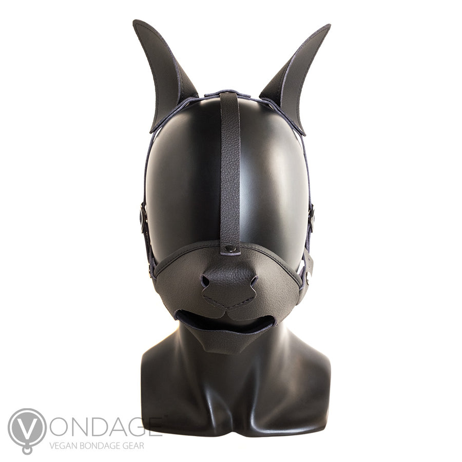 The Vondage Pet Play K9 Muzzle with Removable Ball Gag is shown on a mannequin head. The muzzle is shaped like a dog snout and has a dog nose on it. A black strip of leather runs from the nose to the top of the head, where the dog ears are.