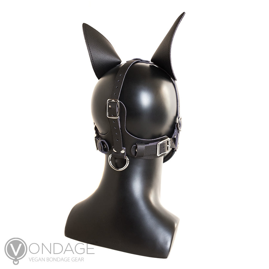 The Vondage Pet Play K9 Muzzle with a Removable Ball Gag is shown on a mannequin head from the back. The muzzle has one vertical strap and two horizontal ones. There is a metal D-ring at the base of the neck.