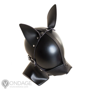 The Vondage Pet Play K9 Muzzle with a Removable Ball Gag is shown on a mannequin head from above. The ears are pointy and attached to a leather strip that runs horizontally across the head. The muzzle buckles near the jaw.