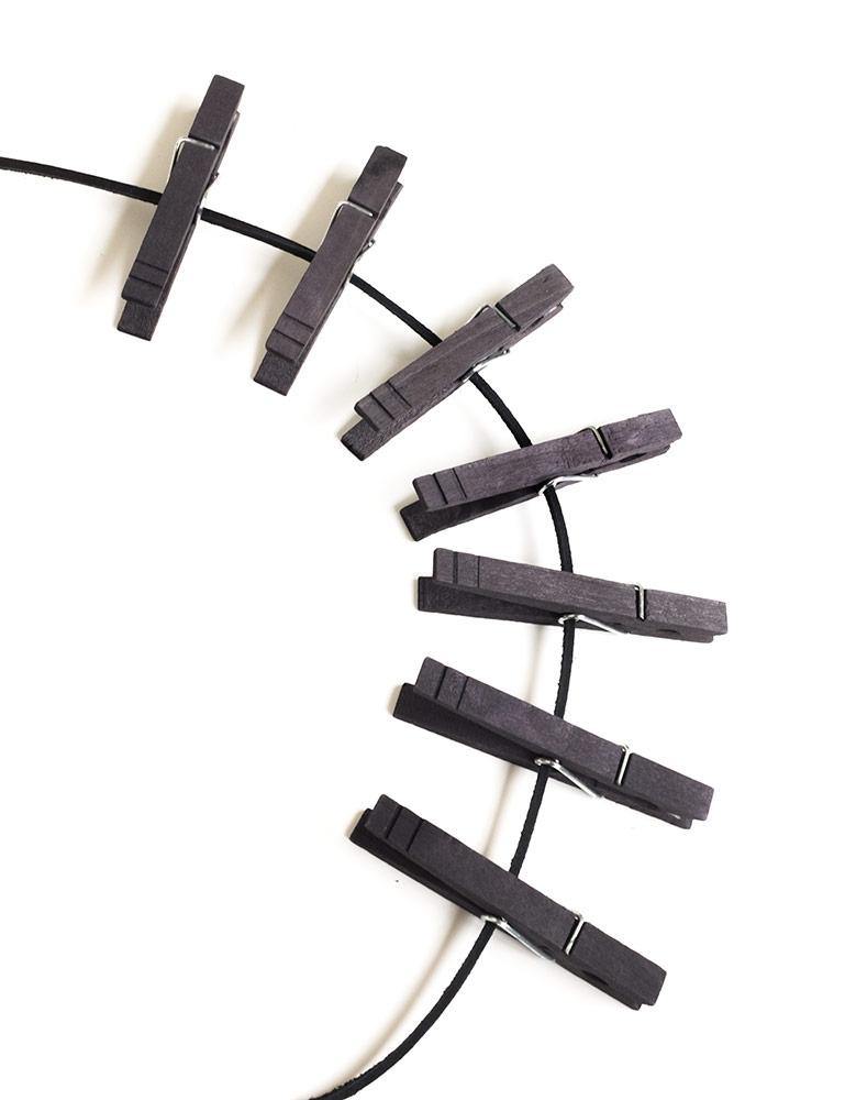 A close-up of a few spaced-apart clothespins from the Extreme Full Body Zipper are displayed against a blank background.