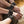 Load image into Gallery viewer, A closeup is shown of a woman’s feet, which are perched on the edge of a dark rattan chair. She is grabbing her feet and is wearing the Fleece Lined Garment Leather Ankle Cuffs and matching wrist cuffs.
