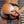 Load image into Gallery viewer, A close-up of a man’s bare butt in a jockstrap is shown with someone holding the Leather Wrapped Round Wood Spanking Paddle against it.
