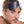 Load image into Gallery viewer, A close-up of a brunette man with light facial hair is shown against a blank background. He has the black Kinklab Bondage Basics Padded Leather Blindfold pulled above his eyes.
