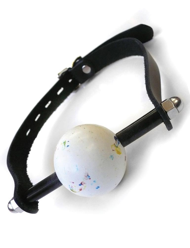 The KinkLab Jawbreaker Gag is displayed against a blank background. The gag is a large jawbreaker candy ball which is white with colored flecks. It is positioned on a black rod attached to an adjustable leather strap.