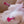 Load image into Gallery viewer, A closeup of a naked woman’s chest is shown. She is using the Kinklab T-Cups Nipple Suction Set with a T-cup suctioning each nipple. The T-Cups are clear with a hot pink twisting mechanism, which have a flower-shaped base.
