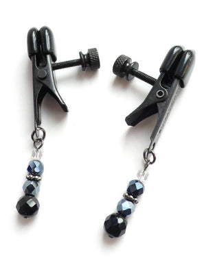A pair of black Beaded Spring Jaw Nipple Clamps are displayed against a blank background. The clamps have rubber tips and a screw to adjust the tension, and each clamp has a string of beads dangling from the bottom.