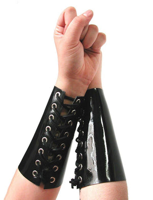 A person's forearms and fists are shown against a blank background. They are wearing the Lace Up Rubber Gauntlets, made of shiny black latex. The gauntlets cover most of their forearm and have corset-style lacing up the middle.