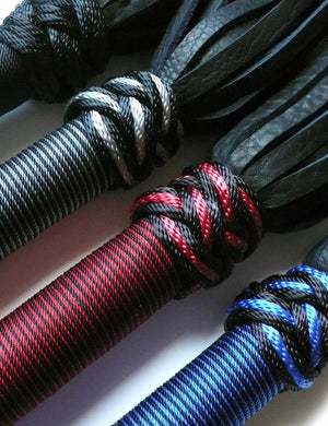 A close-up of the tops of the handles of the 30-inch Elk Hide Floggers in every color is displayed against a blank background.