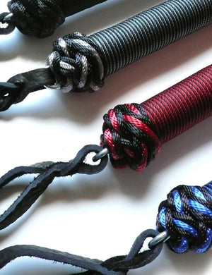 A close-up of the bottoms of the handles of the 30-inch Elk Hide Floggers in every color is displayed against a blank background.