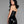 Load image into Gallery viewer, A woman with black hair and red lipstick poses in front of a grey background, facing away from the camera with her head turned over her shoulder. She wears the Latex Halter Dress in black from Syren Latex, which exposes her upper back.
