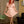 Load image into Gallery viewer, A woman with bright red hair wearing the Ruffly Latex Rubber Heidi Dress in pink stands in a mid-century modern styled room. She is curtsying. 

