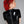 Load image into Gallery viewer, A woman with bright red hair wearing the Latex Back Zipped Cropped T-shirt by Syren Latex in black poses in front of a grey backdrop, facing away from the camera. The shirt has a silver zipper running down the center of the back.

