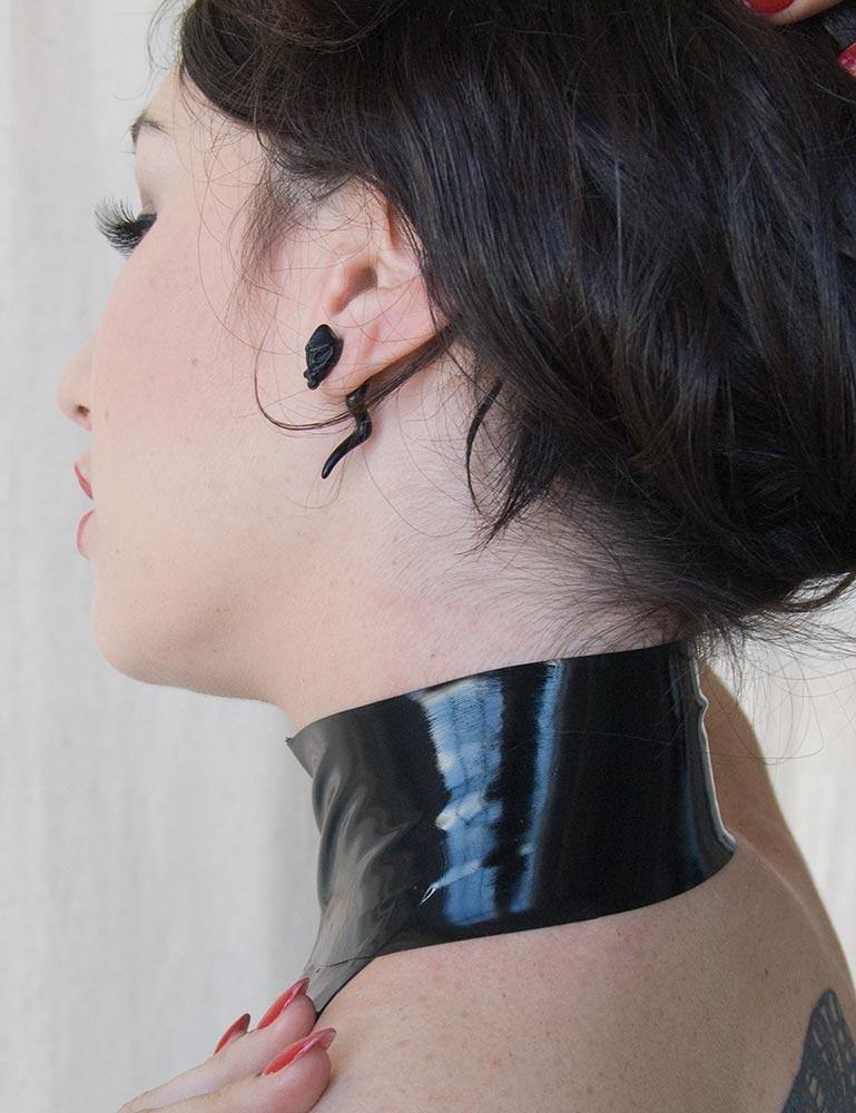 A close-up of the back of a woman's neck in the Latex Halter Top with a Zipper is shown. The halter neck band is wide, resembling a mock neck style top.