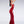 Load image into Gallery viewer, A brunette woman poses in profile in front of a grey background. She wears the red fishtail latex gown from Syren Latex, which hugs her body and flares out at her shins. 
