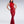 Load image into Gallery viewer, A brunette woman poses in front of a grey background. She wears the red fishtail latex gown from Syren Latex, which has a halter-style neck.
