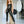 Load image into Gallery viewer, A woman with red hair poses in a photography studio wearing the Latex Tank Suit in black by Syren Latex and platform black heels. The suit has tank top sleeves and a scoop neck.

