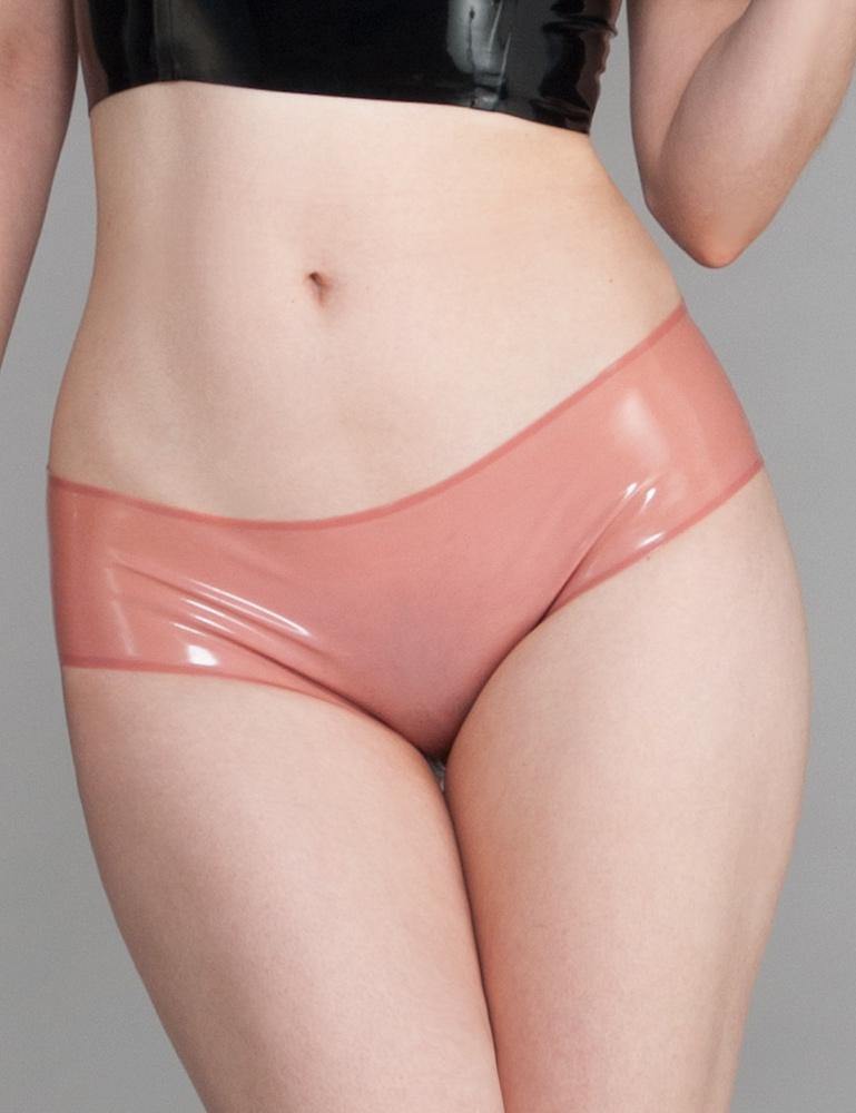 A close-up of a woman's stomach and thighs is shown in front of a grey backdrop. She wears the Cheeky Panty by Syren Latex in rose pink. The panties are low rise and provide full coverage in the front.