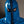 Load image into Gallery viewer, A close-up of a man&#39;s face is shown with the hood from the Executioner Hood by Syren Latex in transparent blue pulled up. The hood is completely zipped around his head and face and has eye hole cutouts. 
