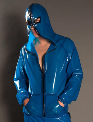 A man poses in front of a grey background wearing blue latex pants and the  Executioner Hoodie by Syren Latex in transparent blue. The hoodie has a double-ended zipper, with one end zipped up to his chest and the other end zipping around the hood. 