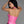 Load image into Gallery viewer, A woman with black hair and red lipstick poses in front of a grey backdrop, facing away from the camera. She wears the Darla Halter Top by Syren Latex in Pearl Pink. The top exposes her upper back.
