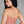 Load image into Gallery viewer, A woman with black hair and red lipstick wearing the Newmar Camisole by Syren Latex in transparent pink poses in front of a grey backdrop.
