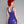 Load image into Gallery viewer, A woman with bright red hair poses in front of a grey background, facing away from the camera and wearing the Latex Tank Dress by Syren Latex in purple. The dress has a low scoop back. 
