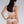 Load image into Gallery viewer, A woman with black hair poses in front of a grey backdrop wearing the Chloe Panty from Syren Latex. The panty has a small cutout with a bow on top at the top-center of the panties. She also wears a matching latex bustier and black latex stockings.
