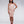 Load image into Gallery viewer, A brunette woman with red lipstick poses in front of a grey backdrop. She wears the Latex Juliette Dress from Syren Latex, which is baby pink with red trim. The dress has a sweetheart neckline and a scalloped hem that cuts off at the knees.
