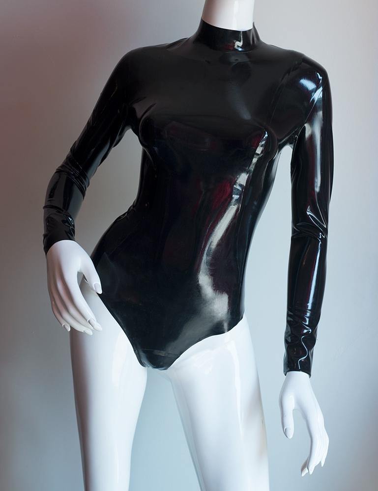 The Nadia Latex Bodysuit in black by Syren Latex is displayed on a female mannequin in front of a grey backdrop.